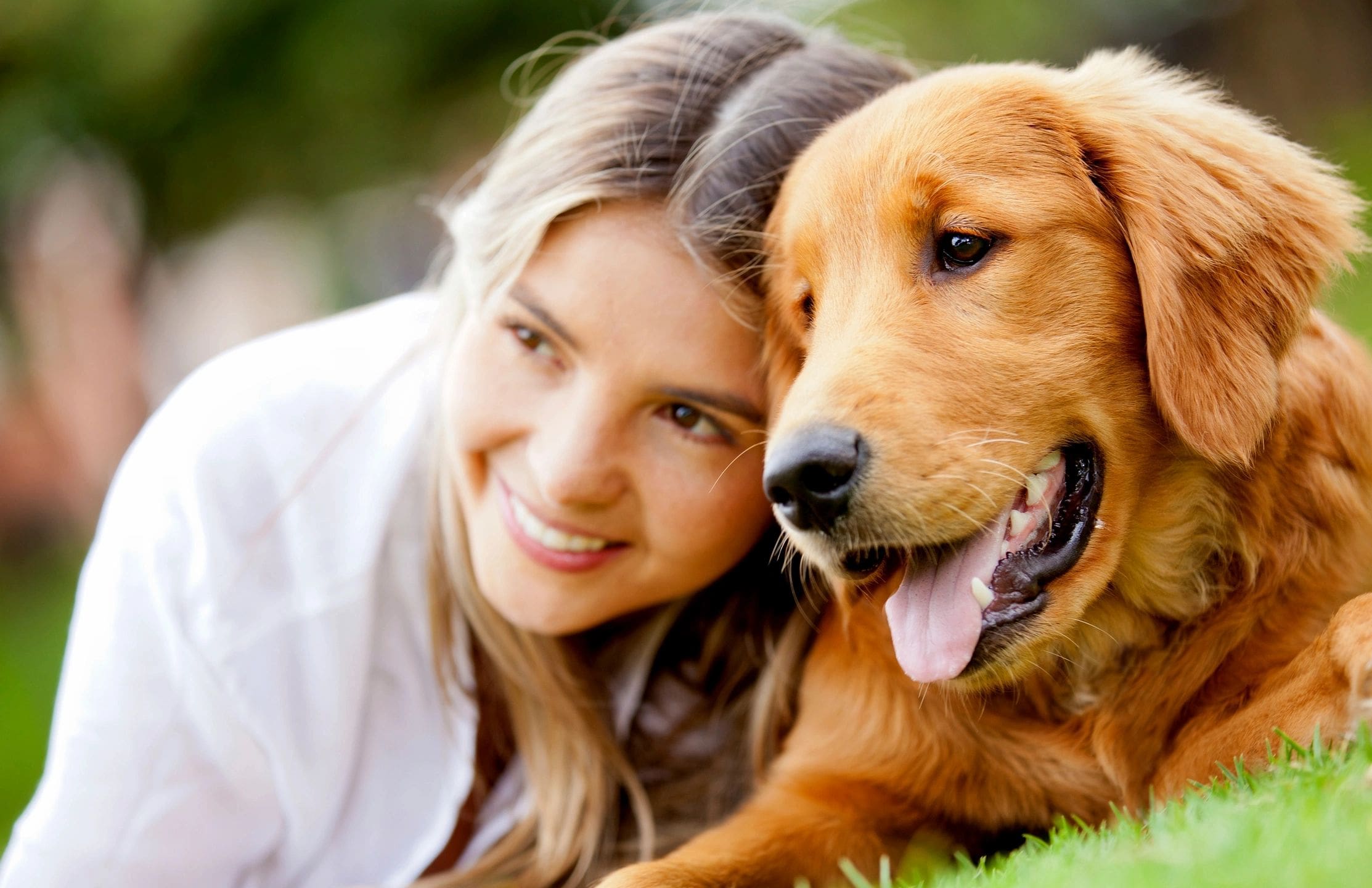 A woman and her dog are smiling for the camera.