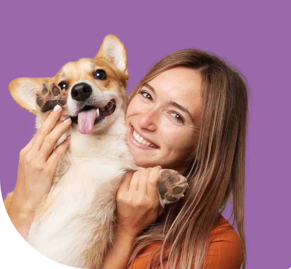 A woman holding a dog with her tongue hanging out.